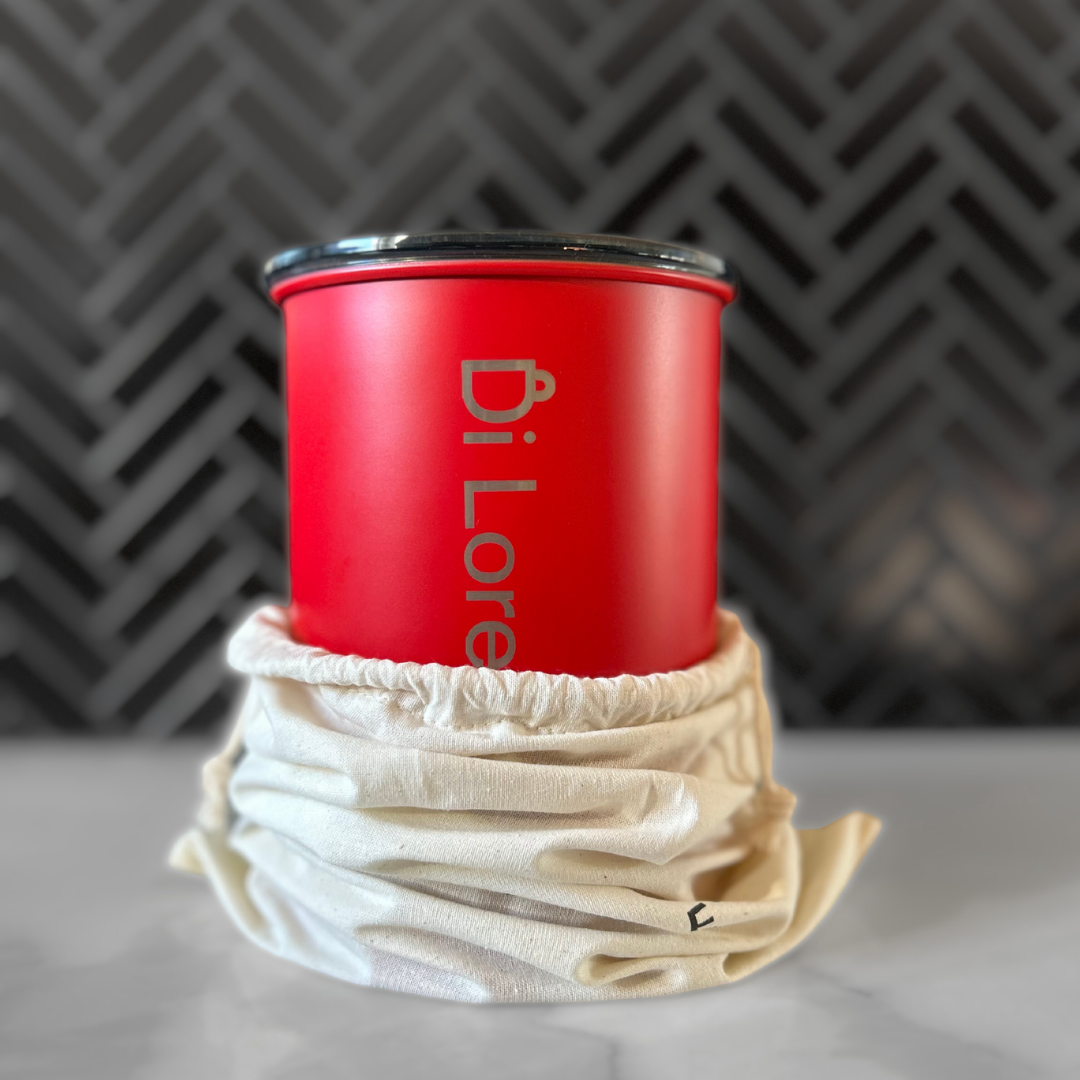 Red coffee canister with 'Di Lorenzo Coffee' branding on a kitchen marble top.