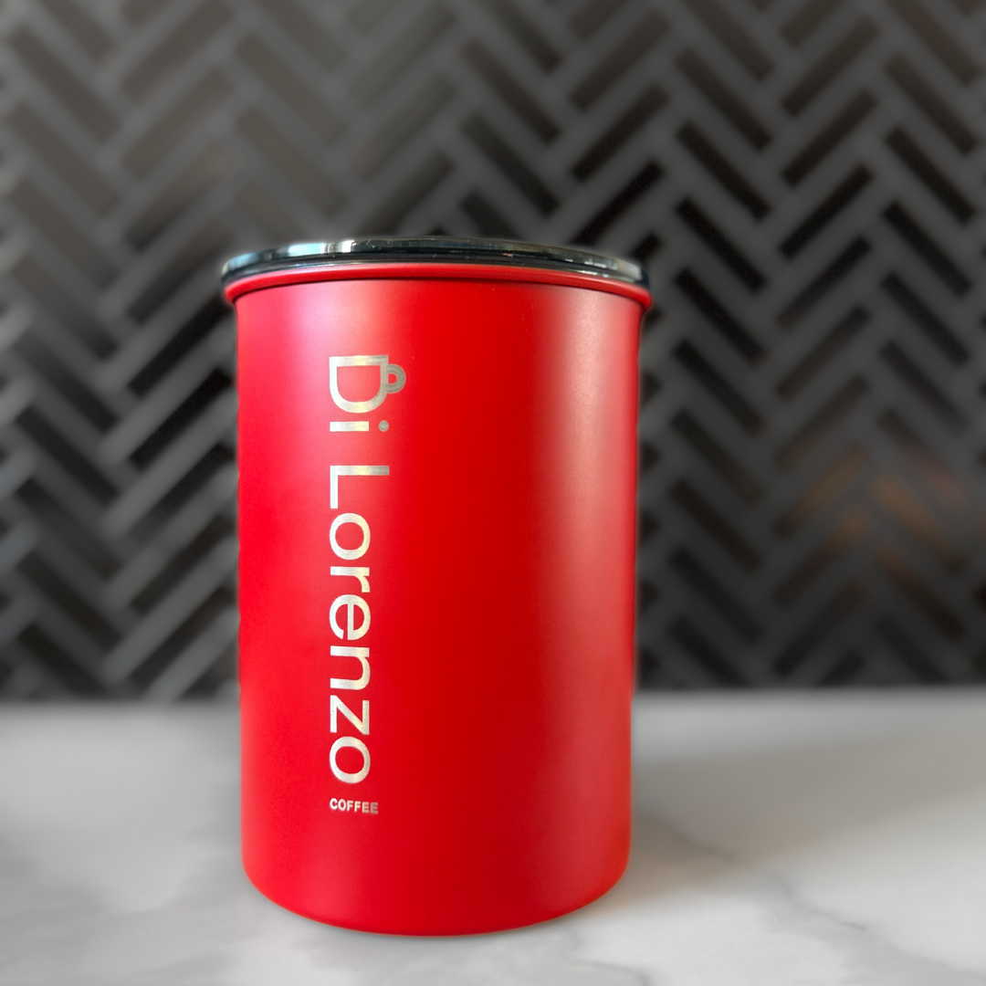 Red coffee canister with 'Di Lorenzo Coffee' branding on a kitchen marble top.