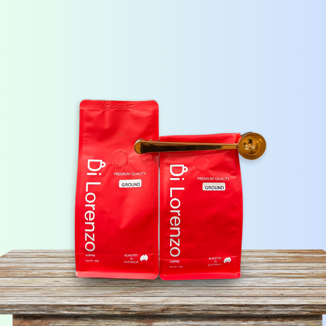 A bright red bag of Di Lorenzo freshly roasted and ground coffee paired with a stainless steel scoop clip, ensuring freshness, displayed on a wooden table with a soft blue gradient background.