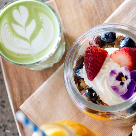 One cup of matcha latte prepared by Di Lorenzo Team accompanied with a granola yogurt bowl for a vibrant healthy and natural breakfast